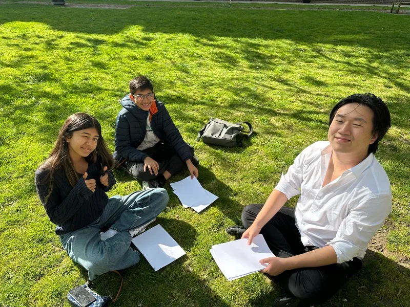 Atlantic Ivy students reading printed drafts with their mentor